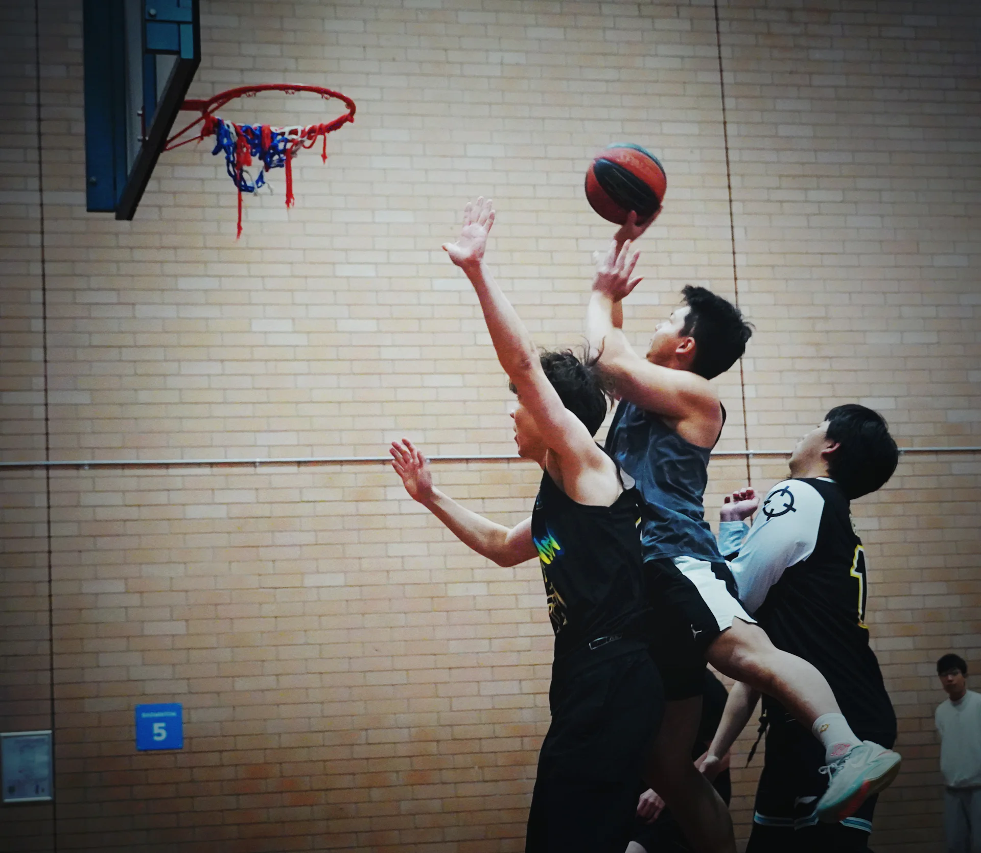 Adults going up for a layup in a recreational basketball game